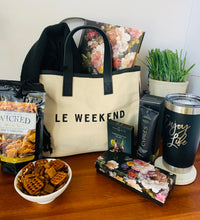 Load image into Gallery viewer, Let her know that you got her by treating her to this loaded gift that&#39;s packaged in a trendy canvas tote.  It includes a deluxe floral journal/diary with matching pen, ultra hydrating hand crème, 20oz. &quot;Enjoy Life&quot; Tumbler, Spicy Snack Mix, Cosmo drink mix (make 2-3 glasses), and an oversized scarf (choose plum or black).  Gift you wife, your bestfriend, sister, mother, girlfriend, or aunt.  Gifts for her. Travel gift
